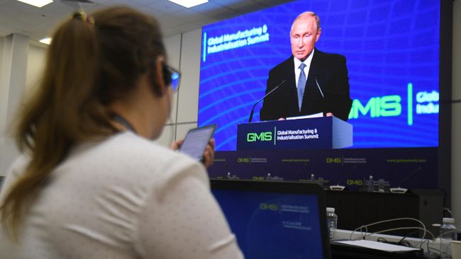 Журналист следит за выступлением президента РФ Владимира Путина на панельной дискуссии в рамках саммита GMIS-2019 в Екатеринбурге Журналист следит за выступлением президента РФ Владимира Путина на панельной дискуссии в рамках саммита GMIS-2019 в Екатеринбурге