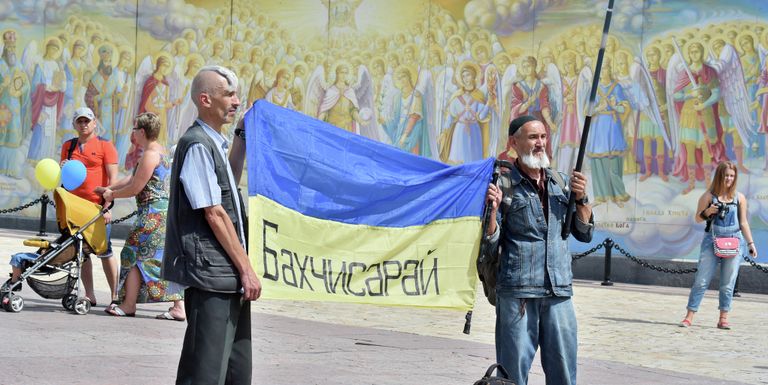 Демонстранты держат флаг Украины с надписью Бахчисарай в центре Киева