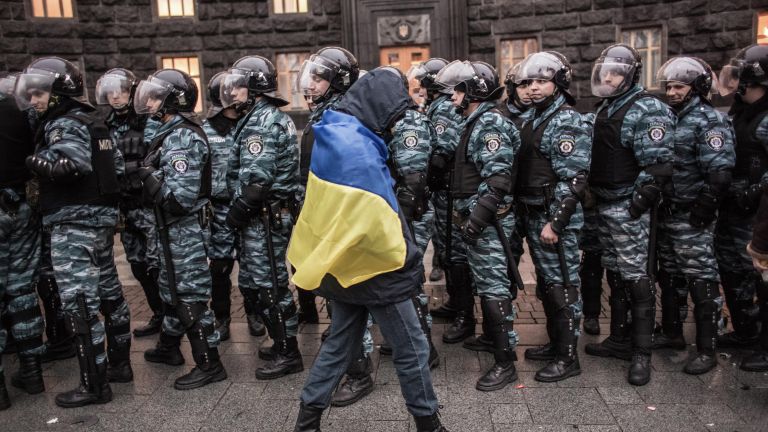 Сторонник евроинтеграции Украины и сотрудники милиции у здания правительства страны в Киеве Сторонник евроинтеграции Украины и сотрудники милиции у здания правительства страны в Киеве
