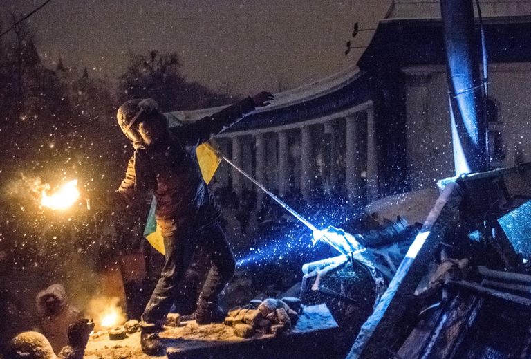 Участник акции протеста кидает бутылку с зажигательно смесью в полицейских на улице Грушевского в Киеве Участник акции протеста кидает бутылку с зажигательно смесью в полицейских на улице Грушевского в Киеве