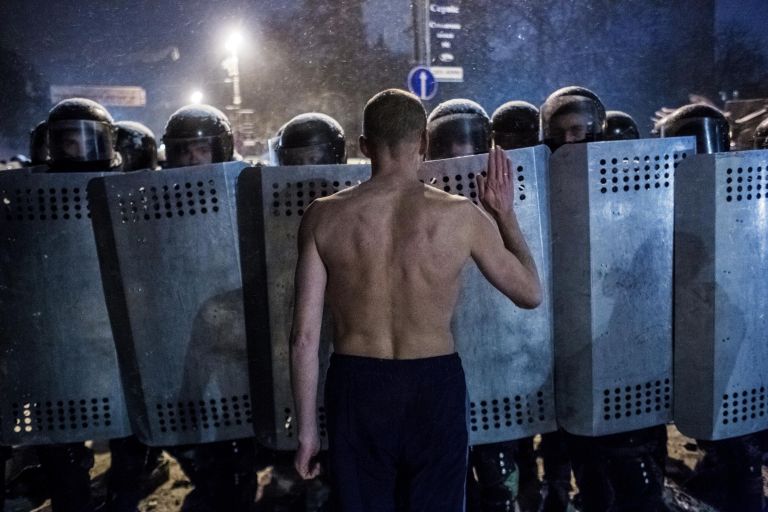 Участник акции протеста разговаривает с сотрудниками спецподразделения милиции Беркут на улице Грушевского в Киеве Участник акции протеста разговаривает с сотрудниками спецподразделения милиции Беркут на улице Грушевского в Киеве