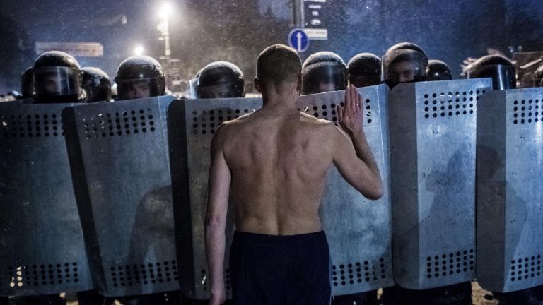Участник акции протеста разговаривает с сотрудниками спецподразделения милиции Беркут на улице Грушевского в Киеве Участник акции протеста разговаривает с сотрудниками спецподразделения милиции Беркут на улице Грушевского в Киеве