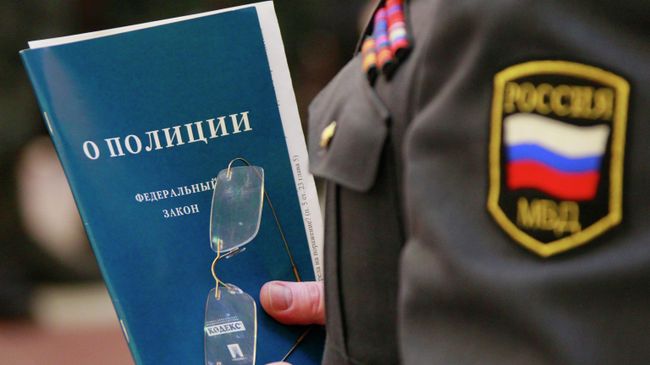 Брошюра с законом О полиции в руках сотрудника МВД Брошюра с законом О полиции в руках сотрудника МВД