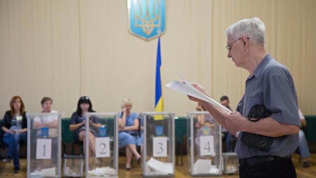Избиратель изучает бюллетень на участке в Киеве, перед тем как проголосовать на досрочных выборах в Верховную раду Украины Избиратель изучает бюллетень на участке в Киеве, перед тем как проголосовать на досрочных выборах в Верховную раду Украины