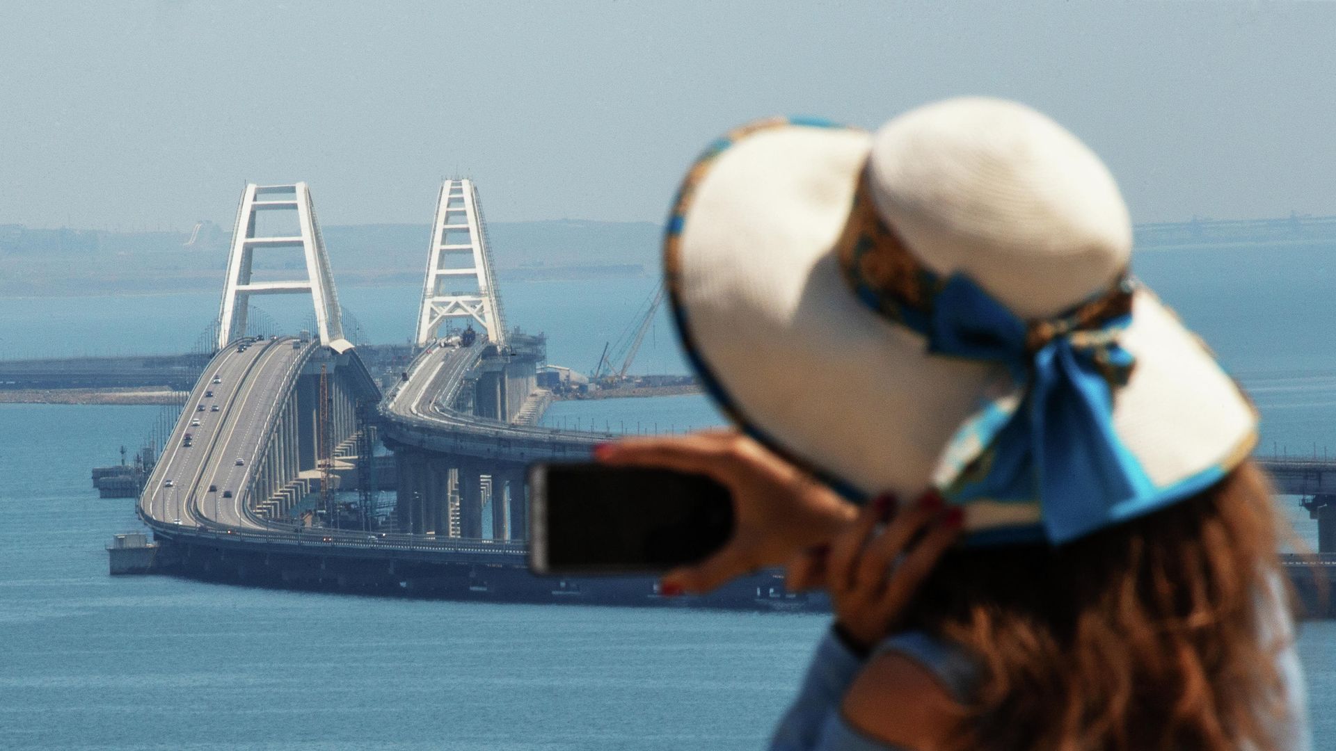 Девушка фотографирует Крымский мост через Керченский пролив Девушка фотографирует Крымский мост через Керченский пролив - РИА Новости, 1920, 28.02.2023