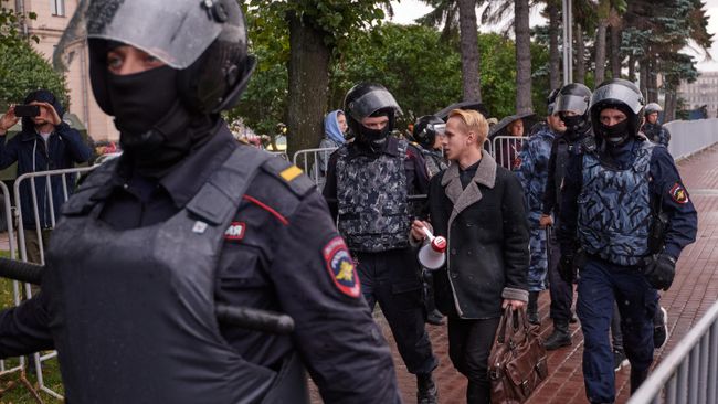 Сотрудники полиции и участник митинга за честные выборы на площади Ленина в Санкт-Петербурге. 3 августа 2019 Сотрудники полиции и участник митинга за честные выборы на площади Ленина в Санкт-Петербурге. 3 августа 2019