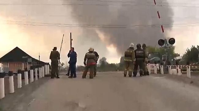 Сотрудники пожарной службы в районе воинской части под Ачинском, где произошли пожар и взрывы на складе хранения артиллерийских боеприпасов. Стоп-кадр с видео