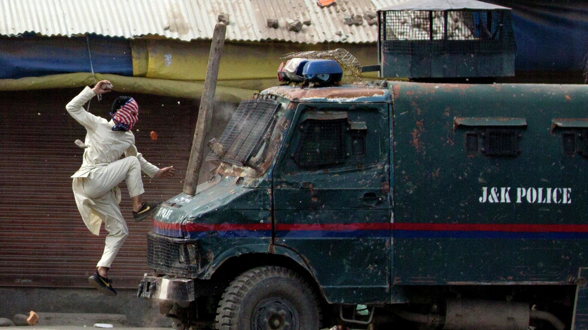 Протестующий в Кашмире прыгает на машину индийской полиции Протестующий в Кашмире прыгает на машину индийской полиции - РИА Новости, 1920, 02.10.2019