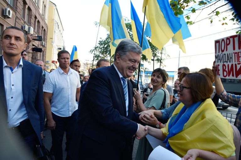 Бывший президент Украины Петр Порошенко пожимает руки своим сторонникам около здания Государственного бюро расследований Украины Бывший президент Украины Петр Порошенко пожимает руки своим сторонникам около здания Государственного бюро расследований Украины