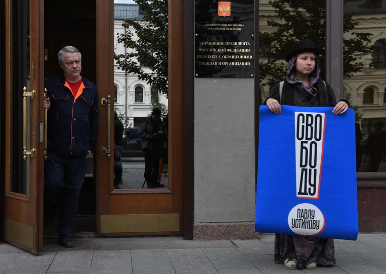Участница одиночного пикета у здания Администрации Президента РФ в поддержку актера Павла Устинова