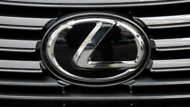 Эмблема Lexus на радиаторной решетке автомобиля Эмблема Lexus на радиаторной решетке автомобиля