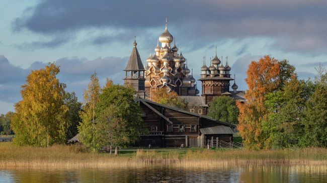 Преображенская церковь XVIII века после реставрации, церковь Покрова Пресвятой Богородицы и колокольня, входящие в состав архитектурного ансамбля Государственного историко-архитектурного музея-заповедника Кижи, на острове Кижи Онежского озера в Карелии