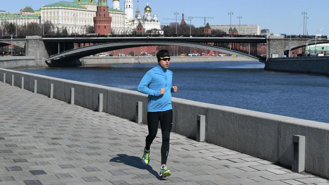 Мужчина бежит по Пречистенской набережной в Москве Мужчина бежит по Пречистенской набережной в Москве