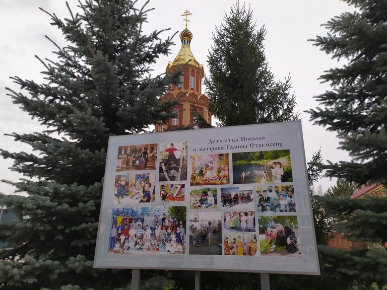 Стенд с фотографиями приемных детей отца Николая, размещен на территории обители Стенд с фотографиями приемных детей отца Николая, размещен на территории обители