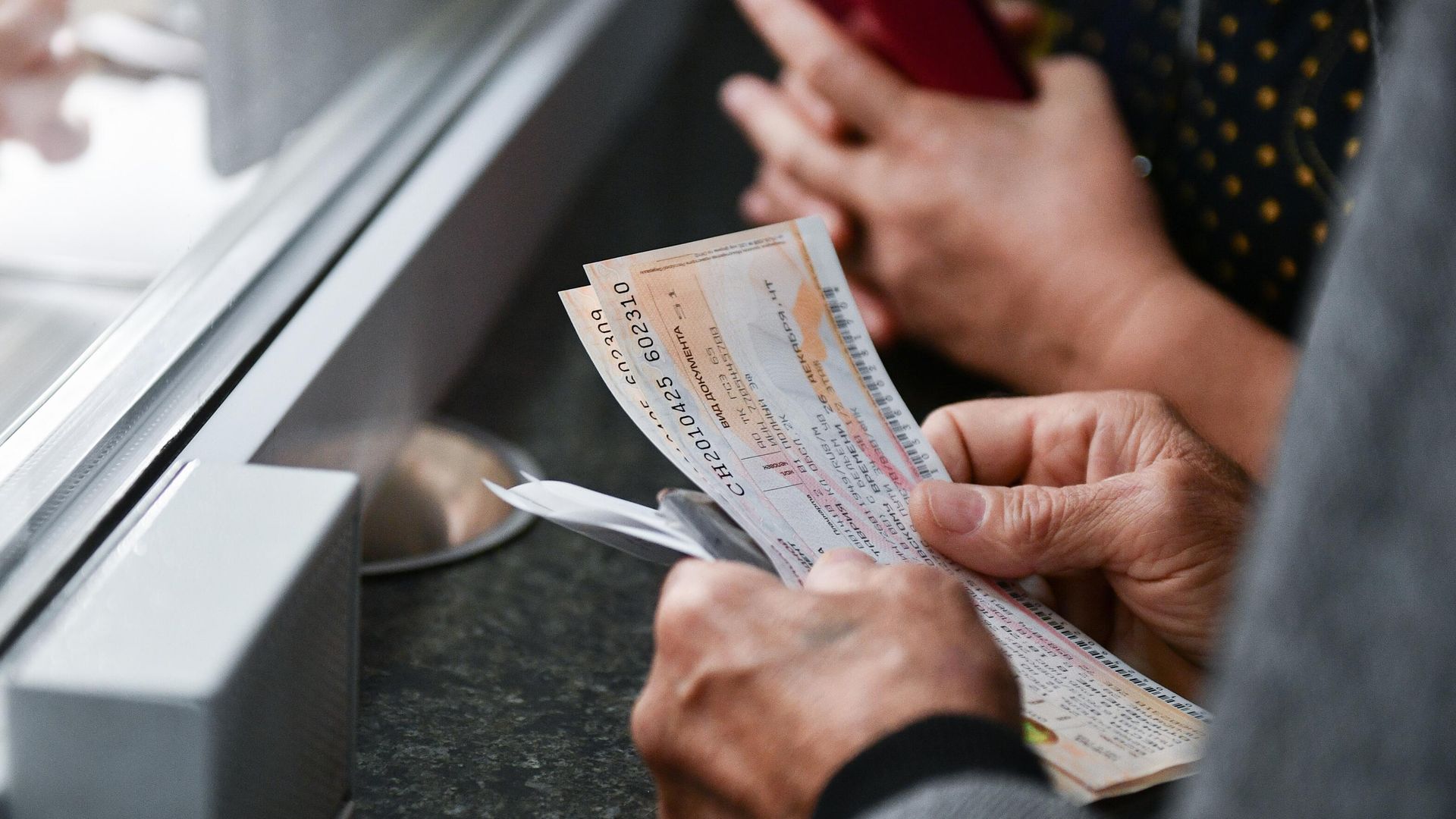 Мужчина покупает билеты на железнодорожном вокзале в Симферополе Мужчина покупает билеты на железнодорожном вокзале в Симферополе - РИА Новости, 1920, 06.04.2022
