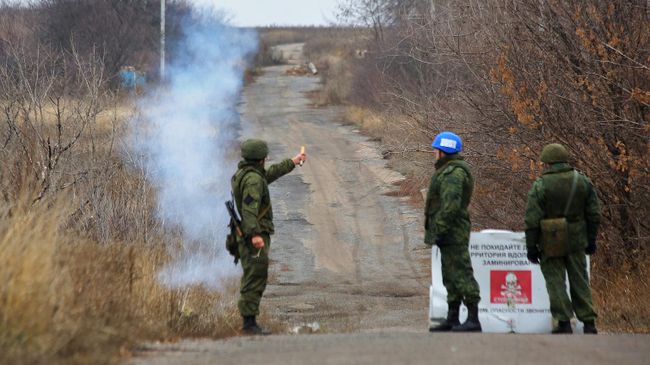 Представитель самопровозглашенной Донецкой народной республики запускает сигнальную ракету как сигнал о готовности вывода подразделений Народной милиции ДНР из участка возле села Петровское Представитель самопровозглашенной Донецкой народной республики запускает сигнальную ракету как сигнал о готовности вывода подразделений Народной милиции ДНР из участка возле села Петровское