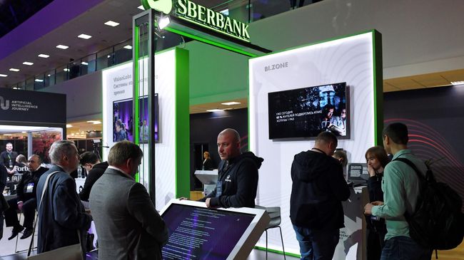 Посетители у стенда компании Сбербанка на конференции по искусственному интеллекту Artificial Intelligence Journey (AIJ) в Москве Посетители у стенда компании Сбербанка на конференции по искусственному интеллекту Artificial Intelligence Journey (AIJ) в Москве