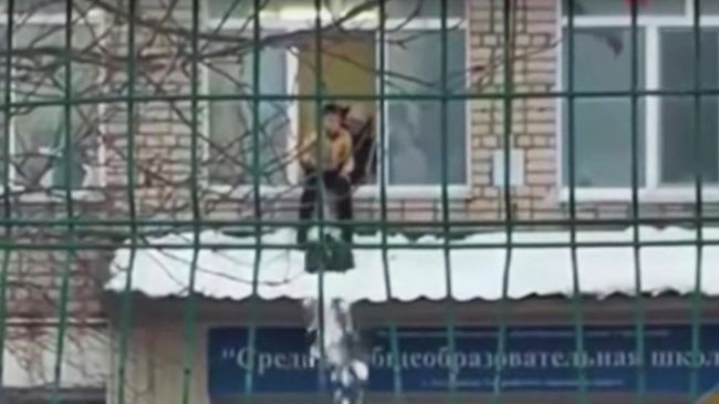 Стоп-кадр видео чистки снега с козырька школы в Приморье ребенком Стоп-кадр видео чистки снега с козырька школы в Приморье ребенком