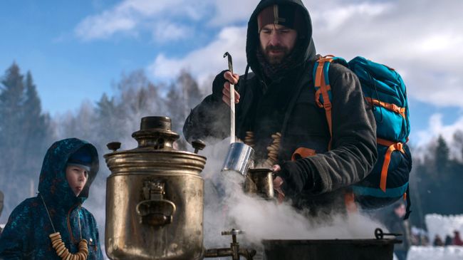 Мужчина наливает горячий чай во время массовых гуляний Мужчина наливает горячий чай во время массовых гуляний