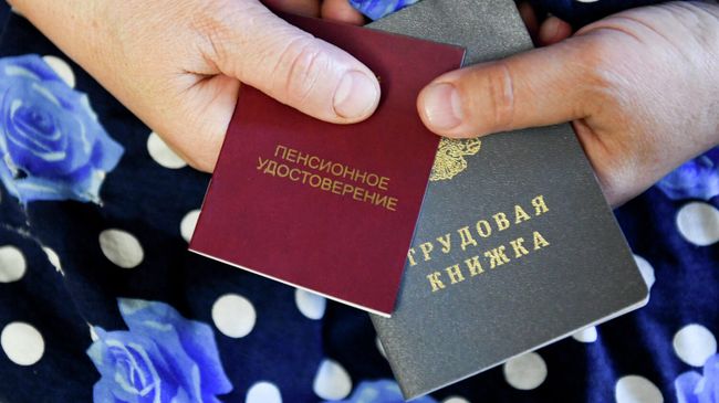 Пенсионерка держит трудовую книжку и пенсионное удостоверение Пенсионерка держит трудовую книжку и пенсионное удостоверение