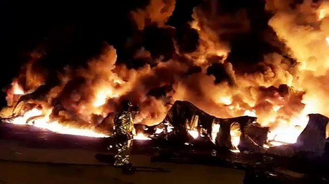 Сотрудники МЧС России тушат пожар в ангаре на территории промышленной зоны в Санкт-Петербурге. Стоп-кадр с видео, предоставленного МЧС Сотрудники МЧС России тушат пожар в ангаре на территории промышленной зоны в Санкт-Петербурге. Стоп-кадр с видео, предоставленного МЧС