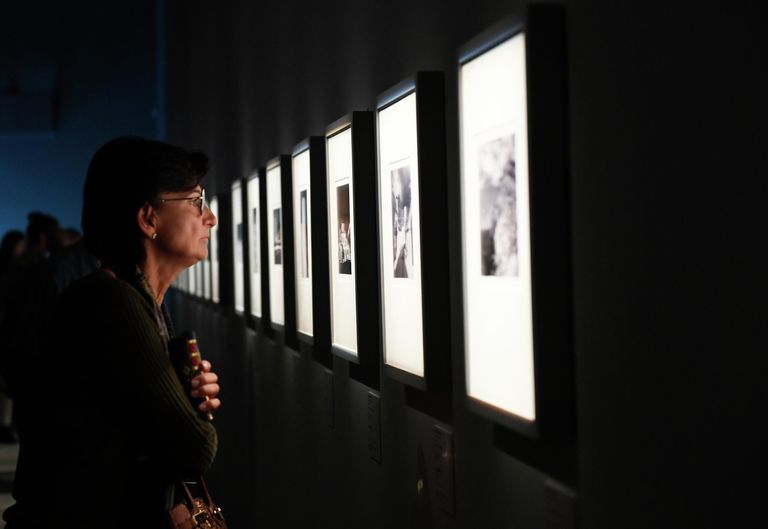 Посетительница выставки работ фотографа Арсена Ревазова Невидимый свет в Третьяковской галерее