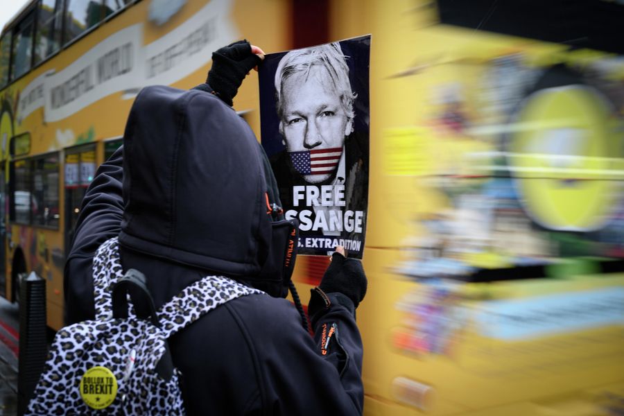 Участник акции против преследования основателя Wikileaks Джулиана Ассанжа держит в руках листовку с призывом освободить Дж. Ассанжа Участник акции против преследования основателя Wikileaks Джулиана Ассанжа держит в руках листовку с призывом освободить Дж. Ассанжа
