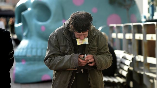 Мужчина считает деньги возле уличного кафе в центре Киева, Украина Мужчина считает деньги возле уличного кафе в центре Киева, Украина