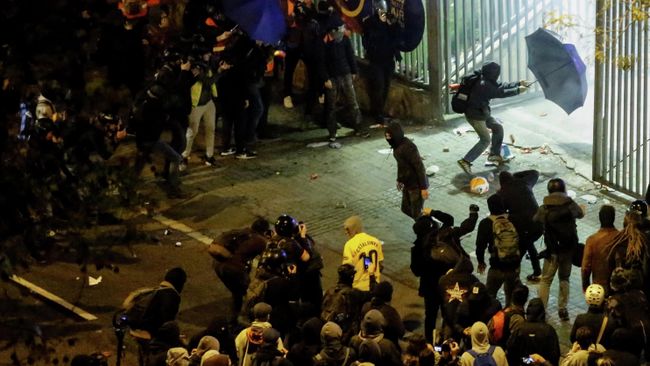 A protester with an umbrella tries to enter the Camp Nou stadium during a protest called by Catalan separatist movement Democratic Tsunami outside the stadium in Barcelona on December 18, 2019, during the El Clasico Spanish League football match between Barcelona FC and Real Madrid CF. - Twelve people were injured as police charged hundreds of masked protesters who set garbage bins on fire near Barcelona's Camp Nou stadium, as Barcelona and Real Madrid faced off in the first Clasico of the season, according to emergency services. (Photo by Pau Barrena / AFP) A protester with an umbrella tries to enter the Camp Nou stadium during a protest called by Catalan separatist movement Democratic Tsunami outside the stadium in Barcelona on December 18, 2019, during the El Clasico Spanish League football match between Barcelona FC and Real Madrid CF. - Twelve people were injured as police charged hundreds of masked protesters who set garbage bins on fire near Barcelona's Camp Nou stadium, as Barcelona and Real Madrid faced off in the first Clasico of the season, according to emergency services. (Photo by Pau Barrena / AFP)