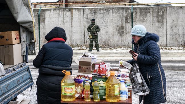 Российский пограничник наблюдает за стихийным рынком на украинской стороне Российский пограничник наблюдает за стихийным рынком на украинской стороне