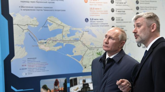 Президент РФ Владимир Путин во время осмотра железнодорожной станции Тамань пассажирская после церемонии открытия движения по железнодорожной части Крымского моста через Керченский пролив. Справа - министр транспорта Евгений Дитрих Президент РФ Владимир Путин во время осмотра железнодорожной станции Тамань пассажирская после церемонии открытия движения по железнодорожной части Крымского моста через Керченский пролив. Справа - министр транспорта Евгений Дитрих