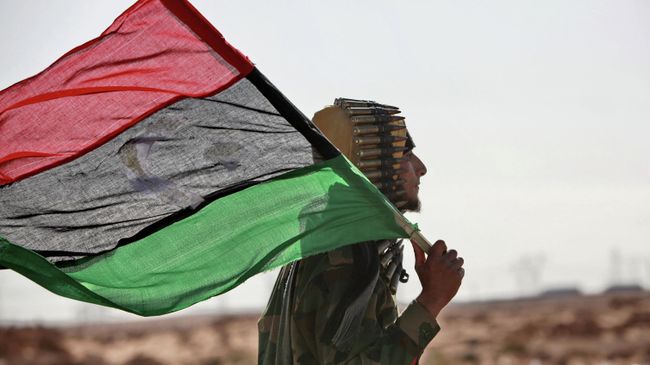 Боец оппозиции с флагом Ливии Боец оппозиции с флагом Ливии