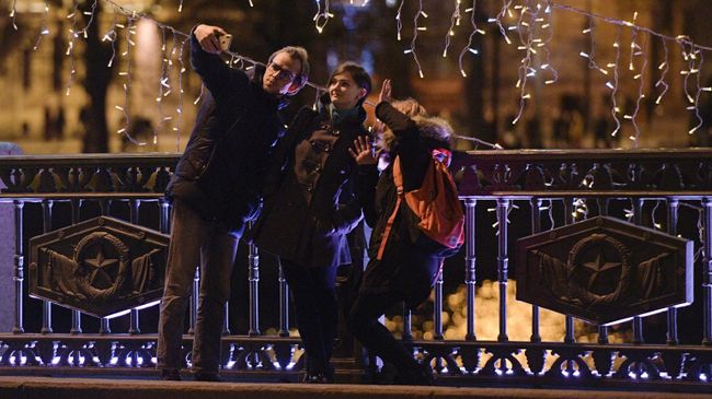 Люди фотографируются на Дворцовом мосту в Санкт-Петербурге в новогоднюю ночь Люди фотографируются на Дворцовом мосту в Санкт-Петербурге в новогоднюю ночь