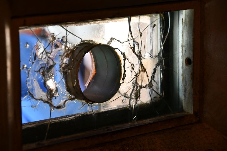 Отверстие в окошке в комнате для свиданий демонстрирует толщину стекла в несколько сантиметров, разделявшего гостя и арестанта