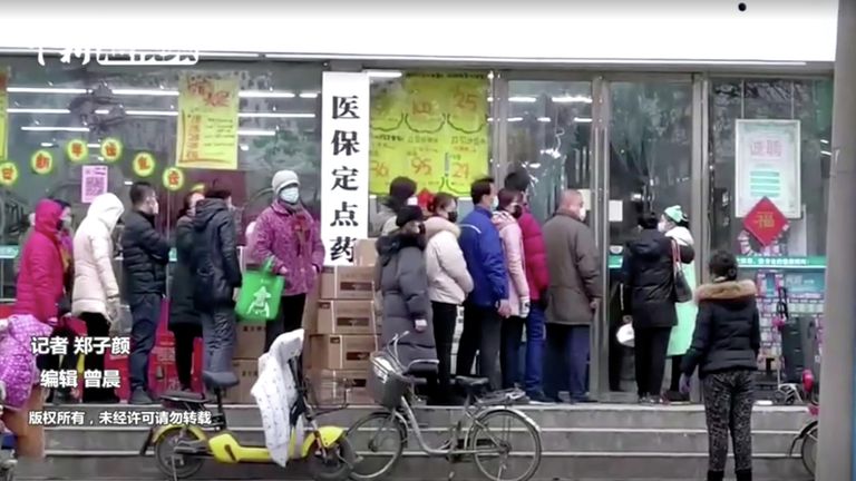 Люди в масках стоят в очереди в магазин в Ухане Люди в масках стоят в очереди в магазин в Ухане