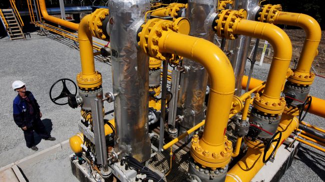 Рабочий у блока сепарационных установок на газораспределительной станции