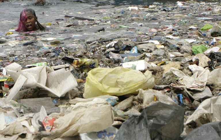 Мальчик плавает в воде залива Манила, Филиппины Мальчик плавает в воде залива Манила, Филиппины