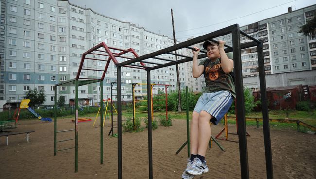 Подросток подтягивается на брусьях в одном из дворов. Архивное фото
