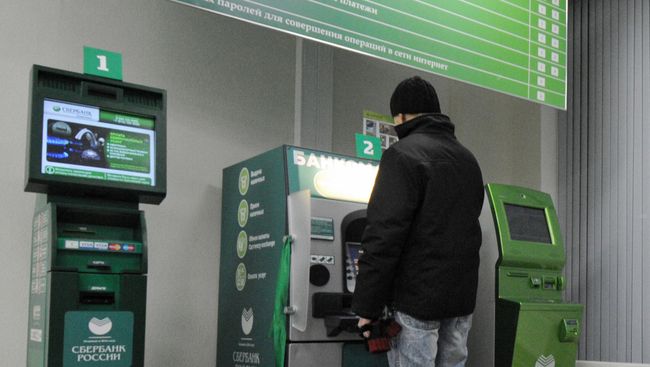 Клиент Сбербанка у банкомата Клиент Сбербанка у банкомата