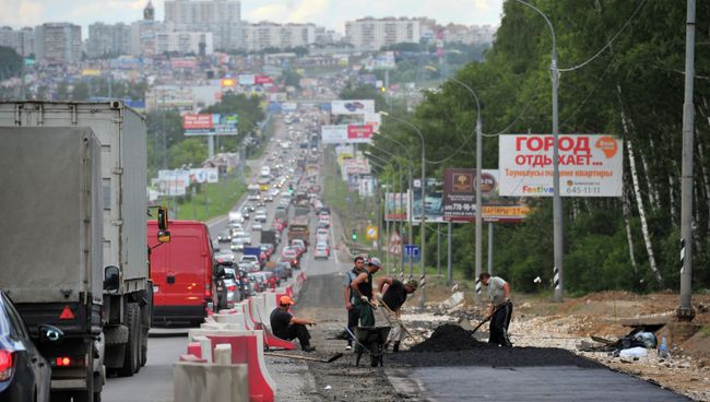 Работники дорожно-ремонтной службы укладывают асфальт на Калужском шоссе. Архивное фото Работники дорожно-ремонтной службы укладывают асфальт на Калужском шоссе. Архивное фото