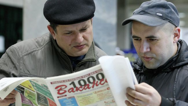 Люди изучают предложения о работе, архивное фото