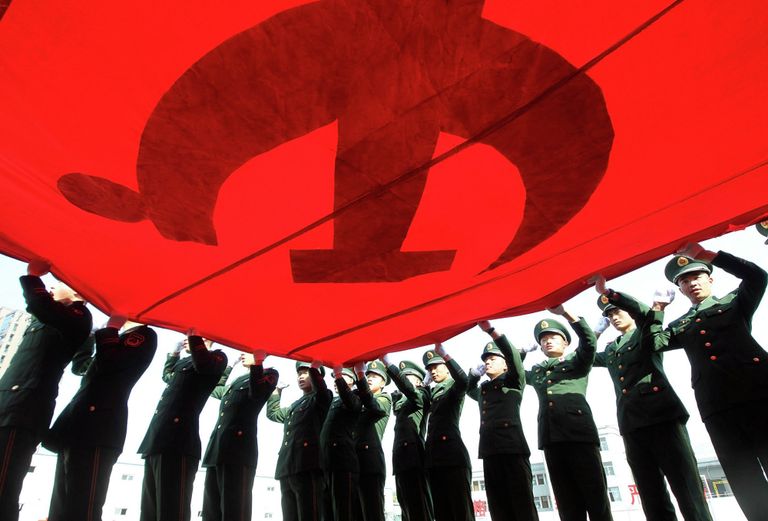 Военизированные полицейские держат флаг Коммунистической партии Китая Военизированные полицейские держат флаг Коммунистической партии Китая