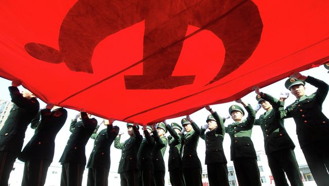 Военизированные полицейские держат флаг Коммунистической партии Китая Военизированные полицейские держат флаг Коммунистической партии Китая