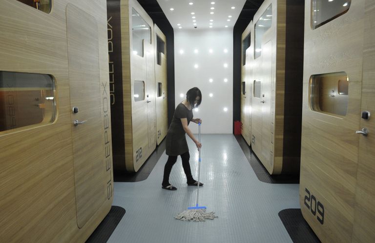 Уборщица моет пол в капсульной гостинице Sleepbox Hotel Tverskaya