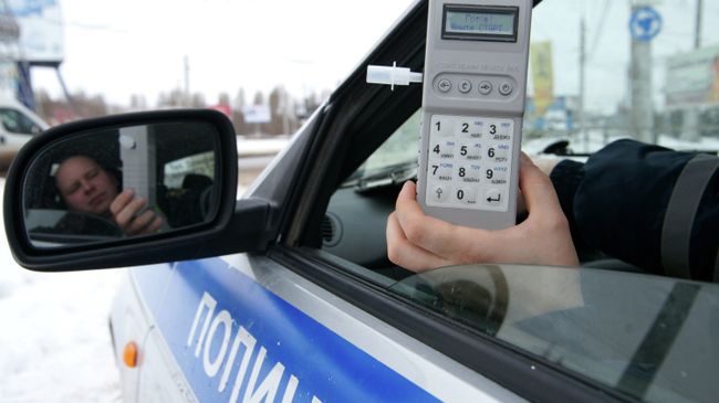 Сотрудник ГИБДД демонстрирует готовый к работе алкотестер Сотрудник ГИБДД демонстрирует готовый к работе алкотестер