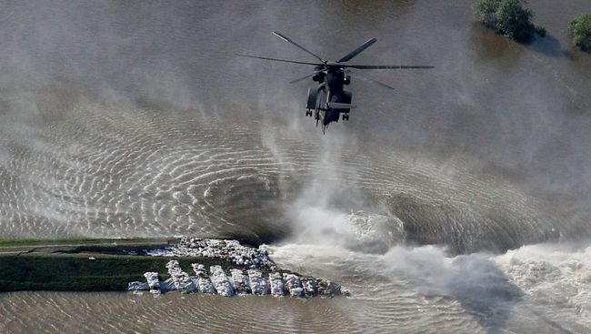 Вертолет сбрасывает мешки с песком на месте разрушенной дамбы в Германии