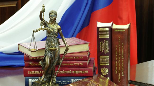 Статуя Фемиды и юридическая литература. Архивное фото Статуя Фемиды и юридическая литература. Архивное фото