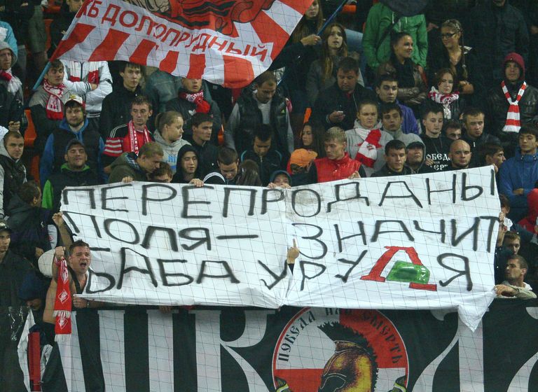 Болельщики футбольного клуба Спартак держат баннер с надписью Перепроданы поля - значит баба у руля, адресованной президенту ФК Локомотив Ольге Смородской