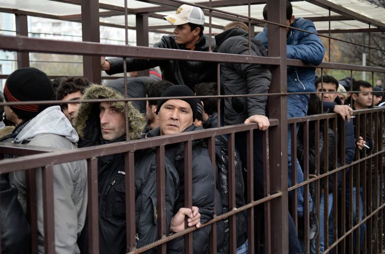 Граждане иностранных государств стоят в очереди в центральное отделение УФМС РФ по Москве