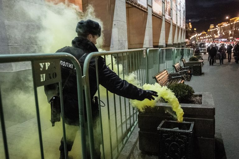 Сотрудник правоохранительных органов выбрасывает файер в урну во время акции Стратегия-31